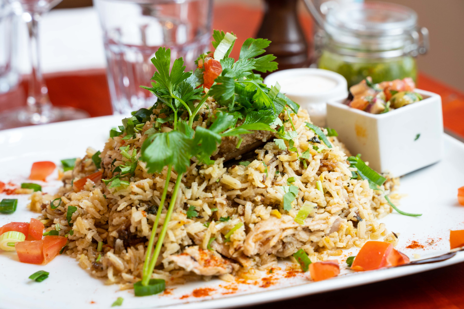 Assiette de biryani parfumé garni de coriandre et tomates fraîches